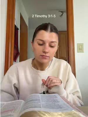 A woman is shown sitting in front of a mirror, reading a book. The image has a natural lighting, with a neutral color palette. A text overlay appears at the top.