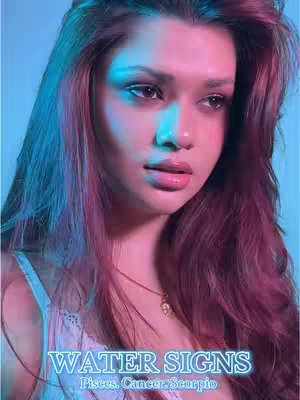 A portrait-style image of a young woman framed from the shoulders up. She has long, wavy auburn hair, and is looking slightly downwards and to the side with a contemplative expression. The background is a gradient of blue and pink. Overlaid on the image is the text 'WATER SIGNS' in a glowing, light-blue neon font, along with 'Pisces. Cancer. Scorpio' in a smaller, also glowing, font.