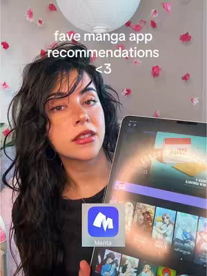 A woman is holding an iPad displaying a manga app with additional text overlayed on the image. She is centered in the frame, looking towards the camera. Behind her, the background features a ceiling light and pink flower petal decorations.