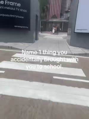 An outdoor shot on a sunny day with a pedestrian crossing in the foreground. The scene captures a walkway with building exteriors and a flag in the background.  A text overlay promotes engagement.