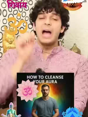 A man with dark curly hair in a pink shirt is the main focus, gesturing with his right hand. Behind him are patterned wallpaper and framed Hindu religious symbols. In the center of the image, the man is holding a small graphic display titled 'HOW TO CLEANSE YOUR AURA' in black letters against colorful background. The display image features an illustration of a man. Overlayed on the image are religious symbols and other graphics. Overall a cluttered image.