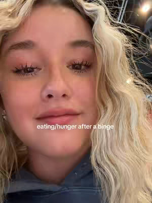 A close up shot of a woman with blonde wavy hair and neutral eye makeup. The text overlay reads "eating/hunger after a binge".
