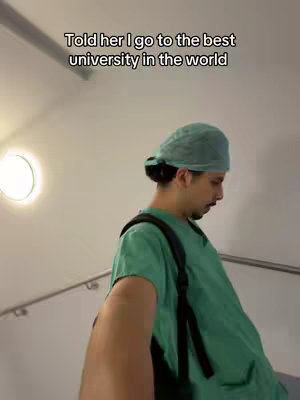 A man in a medical uniform walks down stairs, his back to the camera. The text overlay says, "Told her I go to the best university in the world."