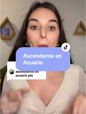 A selfie-style shot featuring a woman looking directly at the camera with a surprised expression. A light blue rectangle with white text covers a portion of her face. Below, a comment bubble with text is near her chest. The background is subtly blurred with wooden decorative elements on display.