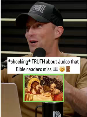 A man with a surprised expression is framed from the chest up, wearing a black baseball cap, and a tan shirt. Behind him is a neutral background. A text overlay at the bottom reads '*shocking* TRUTH about Judas that Bible readers miss' with emojis, and a smaller picture-in-picture displays a painting depicting Jesus with Judas and others. He is positioned in front of a microphone.