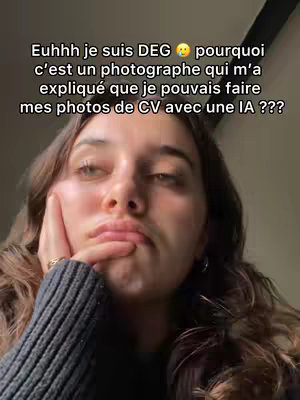 The image is a selfie-style shot with a young woman. She has long, wavy brown hair and is wearing a dark gray sweater. She rests her head in her left hand, with an expression of slight sadness or frustration. The background is a neutral, softly lit space, and text overlays appear at the top of the frame.
