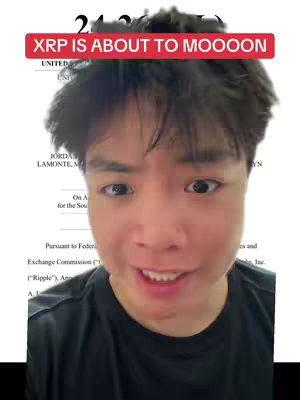 A young man with dark hair is shown in a selfie-style video. He has a slightly surprised expression and is turned towards the camera. Behind him is a document with part of it visible. The image is overlain with a red banner that includes the text.