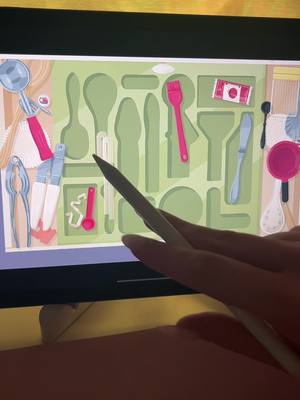 A person's hand holding a stylus over an iPad screen. The screen displays an organized set of kitchen utensils in a green grid. The utensils are stylized, cartoon-like, in various colors. The background is a light peach color.