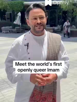 A man in a white shirt and draped scarf stands outdoors with a smiling expression. A text overlay reads 'Meet the world's first openly queer Imam'. The background suggests an outdoor cafe setting.