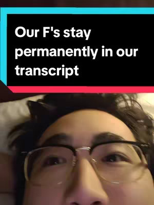 A selfie-style image featuring a close-up of a person wearing glasses, against a soft, blurred background. The person looks up towards the camera, and there is a text overlay at the top of the image with the phrase 'Our F's stay permanently in our transcript'. The background is a dark interior with undetailed elements and colors.