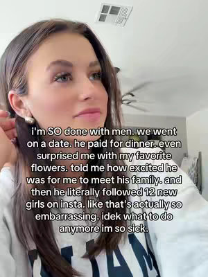 A selfie-style shot featuring a young woman with long brown hair, angled slightly right. She is looking towards the lower right of frame, with text overlaid on the image. The background is a blurred interior space.