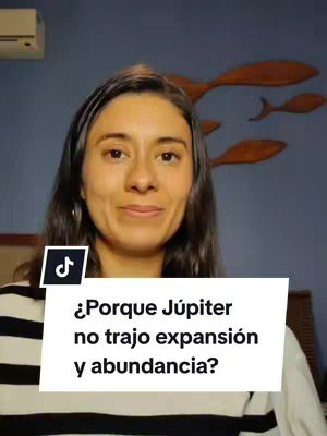 A woman with dark hair and a neutral expression looks toward the camera. Below her is a white rectangular panel with the question, "¿Porque Júpiter no trajo expansión y abundancia?" in bold, black text. The background shows a blue wall decorated with wooden fish.