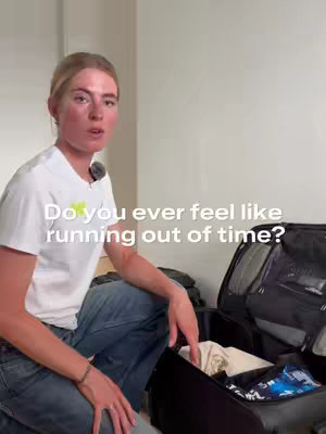 A woman with blonde hair sits with an open suitcase in front of her, speaking directly to the camera. Text overlay 'Do you ever feel like running out of time?' is visible on the lower-center part of the screen