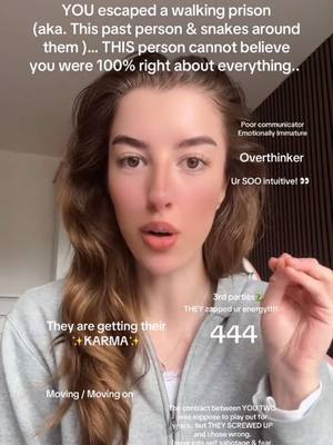 The cover image is a selfie-style shot of a woman with long, wavy brown hair, angled slightly upward capturing her face. Her expression is one of gentle surprise or seriousness, with her eyebrows slightly raised and her lips slightly parted. Overlaid on the image are several superimposed text elements in a clean, sans-serif font, including phrases such as "YOU escaped a walking prison", "Overthinker", and "They are getting their +KARMA+". Additional text includes the number "444". The background appears to be a neutral, blurred indoor setting, with the woman in a gray hoodie. The image's composition includes text boxes in the upper left, upper right, and lower left quadrants, with a rectangular text box at the image's bottom.
