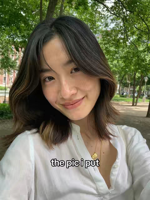 A woman with dark hair smiles at the camera while posing outdoors with trees and a building in the background. A white text overlay that says "the pic i put" is on the bottom of the image.