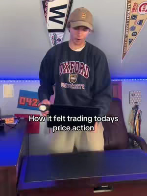 A young man in a sweatshirt and cap stands in front of items hanging on a wall, holding a tablet. The text overlay reads, How it felt trading todays price action.
