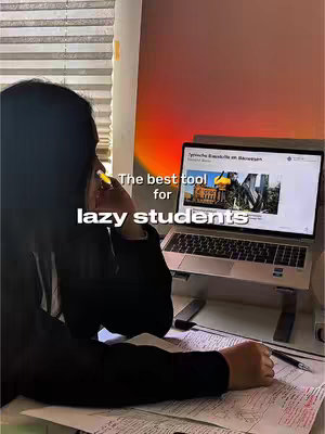 A woman is sitting at a desk, slightly turned away from the camera, with a laptop open in front of her. The laptop screen displays text and images. She is holding a stylus and there is a notebook on the desk. The background is a gradient from red to orange. Text overlayed reads "The best tool for lazy students".