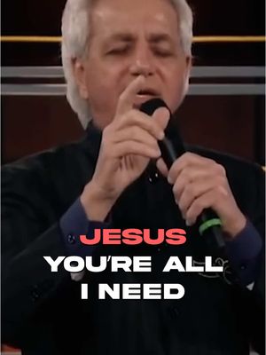 A man with gray hair and a black suit is holding a microphone. Text overlayed on the lower portion of the image reads 'JESUS YOU'RE ALL I NEED'.