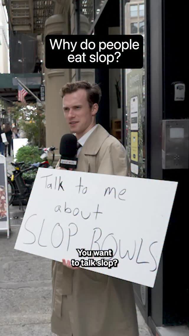 A man in a tan coat stands in front of a storefront, holding a white sign. Text on the sign says, 'Talk to me about SLOP BOWLS' with the text 'Why do you want to talk slop?' below.