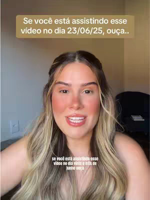 A woman with long blonde hair, wearing makeup, smiles directly at the camera. The background is simple, with a wall visible. Text overlays are placed on the image.