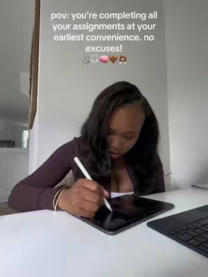 A young woman sits at a desk with a tablet and a laptop. She is working on the tablet with a stylus. The background is a plain wall. Text overlay: "pov: you're completing all your assignments at your earliest convenience. no excuses!" 