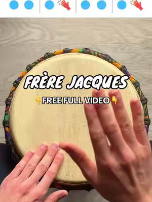 The image shows a close-up view of a drum from above, with the surface of the drum centered in the frame. Two hands are visible, one on each side of the drum, with the fingers gently touching the drumhead, as if ready to play. The drum itself has a light tan surface. The background appears to be a light wooden texture. Above the drum, there are a series of small blue circles and hand symbols, the hook text "FRERE JACQUES FREE FULL VIDEO" is placed on the drum surface. The image is well-lit, and the colors are natural and inviting.