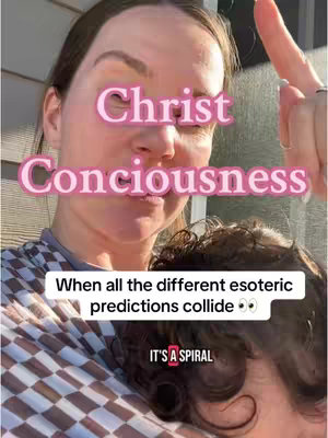 A selfie-style image featuring a woman holding a child. Overlay text in a pink font reads "Christ Consciousness" on top, with additional text in a white box stating "When all the different esoteric predictions collide". The logo "It's a Spiral" is placed at the bottom. The woman is fair-skinned with light brown hair, the child has dark hair.
