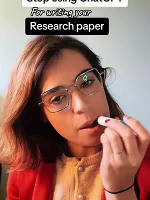 A woman in a red blazer and glasses is applying lip balm, with overlaid text about research papers. The image is a close-up, focusing on her face and the lip balm tube.
