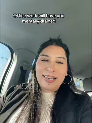 A woman with dark hair and gold hoop earrings is smiling in the driver's seat of a car. Text overlaid says, "Office work will have you mentally drained."