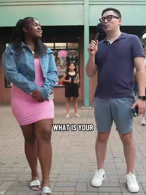 The cover image features a man holding a microphone, seemingly interviewing a woman in a pink dress and denim jacket. They are standing on a brick-paved area, with a building and another person visible in the background. The overall composition is bright and casual, suggesting a street interview setting.