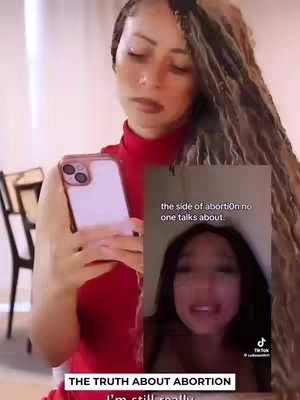 A woman holding a pink phone, seemingly in the middle of filming herself or recording her screen. A smaller video is superimposed on the right side of the image, displaying another woman speaking.