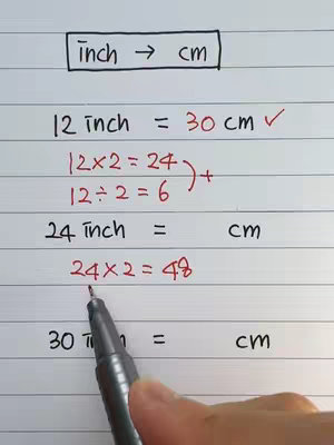 A close-up shot of a white sheet of paper with handwriting. At the top is the title "inch -> cm" within a black rectangle. Below, equations relating inches to centimeters are written in black and red ink, with a hand holding a black pen in the lower right corner.