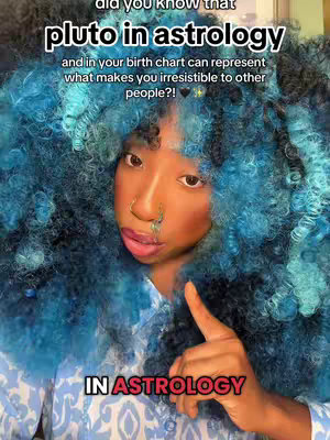 A selfie-style image featuring a person with blue, voluminous hair. The person appears to be pointing with one finger, and overlay text adds information about Pluto in astrology.
