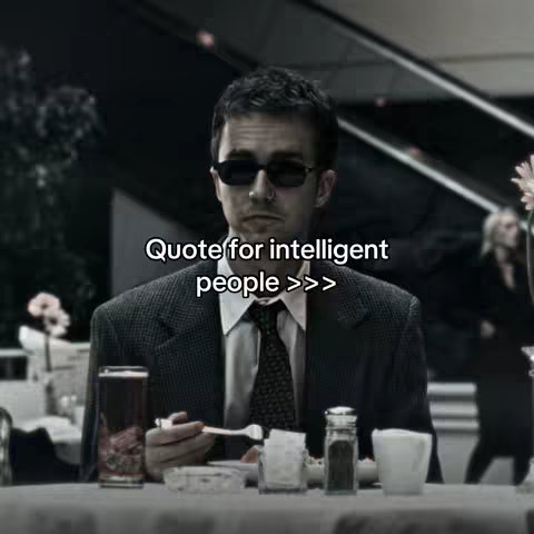 A photo featuring a man in sunglasses seated at a table with a drink, cutlery, and a condiment set. The background is slightly blurred, showing a cafe setting with other people. Overlaid text reads "Quote for intelligent people >>>".
