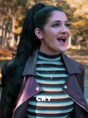 The cover image features a young woman with dark hair pulled back in a high ponytail. She is looking up and slightly to the right with her mouth open in mid-sentence. She's wearing a striped turtleneck top, a light necklace with a cross pendant and a dark, open jacket. In the bottom center of the image is the word "CRY" in white font.