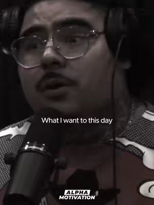 The cover image features a close-up of That Mexican OT, a male rapper, wearing glasses and headphones, speaking into a microphone. The image has a dark, muted color palette, and the text overlay reads "What I want to this day". The composition is focused on the rapper's face and upper body, with the microphone prominently placed in the foreground.