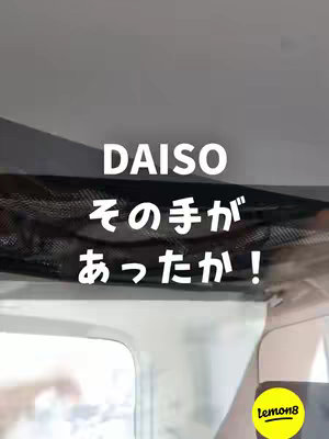 The image shows a car interior. A black mesh net is visible, attached to the car's roof. The text "DAISO その手があったか！" is overlaid on the image.