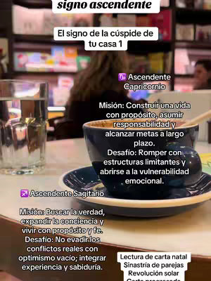 The image features a table setting with a cup of coffee, a water glass, and various handwritten texts about astrological signs. The foreground showcases a dark blue cup of coffee on a saucer, with text overlayed giving details on astrological signs related to rising signs. To the left, a glass of water is placed, providing a balance to the composition. The overall image has a warm, inviting tone, with the background suggesting an indoor setting, perhaps a café or a home.
