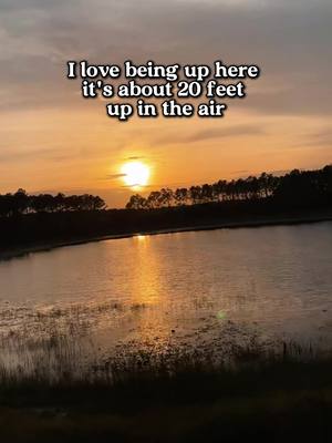A serene sunset scene over a calm body of water, probably a lake or a portion of a river. The sky is filled with warm orange and yellow hues, and the sun is near the horizon. The water reflects the sky's colors. Silhouetted trees line the distant shore, and text is overlaid at the top, written in a casual, sans-serif font.