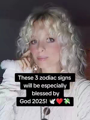 A woman with curly blonde hair looks toward the viewer with a thoughtful expression. Text overlays in a black box state: "These 3 zodiac signs will be especially blessed by God 2025!" with emojis of a dove, heart, and money. The background is a dark grey.