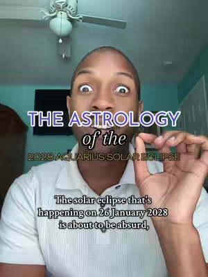 The cover image features a man with a surprised expression, wearing a white collared shirt. Overlay text in white and teal discusses the astrology of the 2028 Aquarius solar eclipse. The background includes a TV, a ceiling fan, and a teal wall.