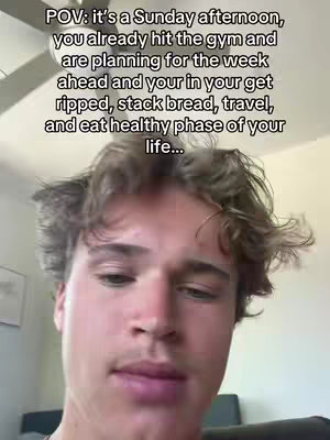 A selfie-style video. The main subject is a young man facing the camera. Text overlay appears at the top of the image. Other elements are blurred due to the closeness of the shot.