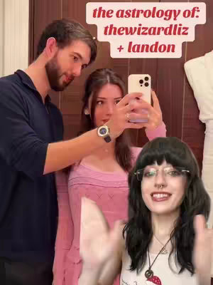 The image is a selfie-style shot with three people and text overlay. Three people are arranged in the frame with the main focus on a woman in a white top, glasses and a nose ring . To her left are a woman taking the photo and on her left is a man. The background has a neutral color. The text overlay is in the upper area, with the light of the phone casting on their faces.