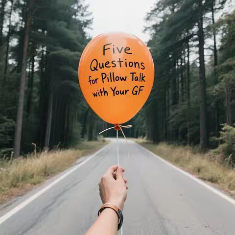An orange balloon with black text against a blurred background of trees and a road. A hand is holding the balloon, with a bracelet around the wrist. The sunlight is bright, creating a warm tone. The road leads into the distance, drawing the eye.