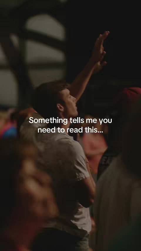 A vertical shot showing a man from the side, head and arms raised. The man is looking up and to his right, with his right arm raised with the hand pointing upwards. The background is out of focus, but appears to show a group of people in a dimly lit area. Text overlays indicate what the video is about.