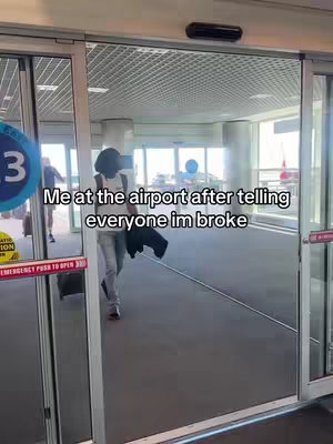 A person wearing a black hat, white shirt and jeans walks through automatic glass doors at an airport. The doors are open. There are other people in the background. Text is overlaid on the image.