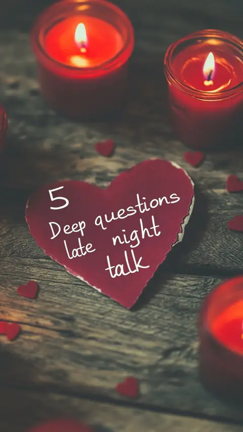 A close-up shot of a wooden surface with several red, lit candles and scattered heart-shaped confetti. In the center, a red heart-shaped piece of paper has the text '5 Deep questions late night talk' written on it in white.