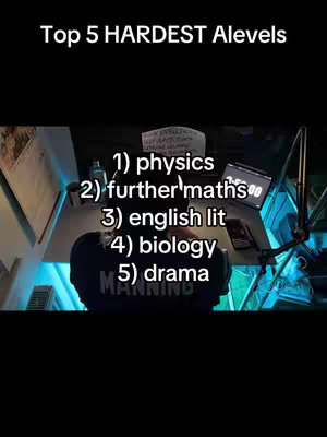 The cover image is a top-down view of a workspace, likely a desk. The top of the image has white text that overlaps the content. White text list 5 A-level subjects. The bottom of the image shows the back of a person wearing a black t-shirt. The overall composition has a dark aesthetic.
