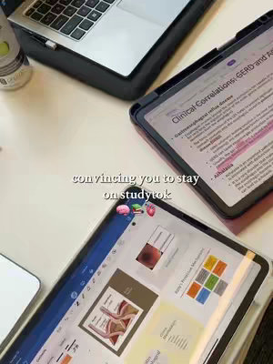 The image shows a desk setup with a laptop, two tablets, and a bottle. One tablet displays notes about clinical correlations of a disease, the other displays an outline of a medical diagram, and the laptop is partially visible. Text overlayed on the image says: "convincing you to stay on studytok", along with several small icons near it . The overall lighting is bright, and the background is a neutral white surface.