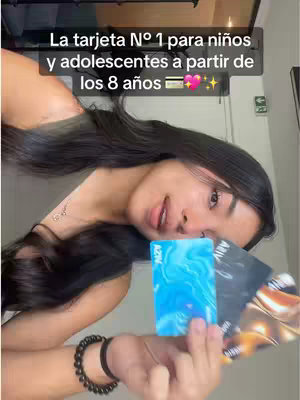 A young woman with long black hair is shown in a selfie-style video. She is holding a stack of credit cards and smiling. Text overlays at the top describe it as the number 1 card for children and adolescents starting at 8 years old.